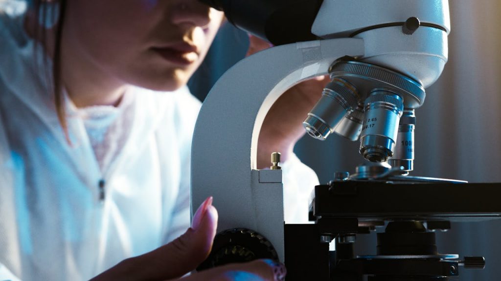 Person Looking Through the Microscope